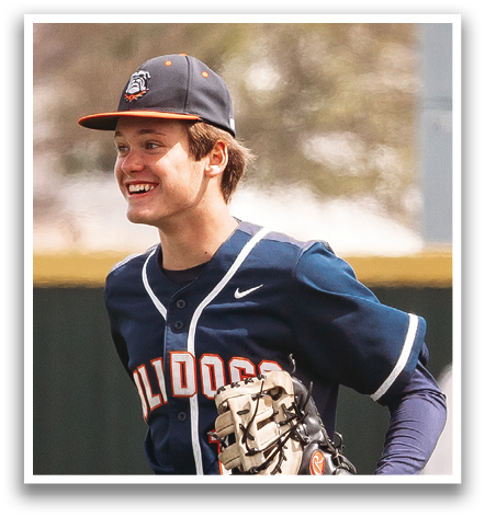 A baseball player wearing a blue shirt and a baseball glove is walking on a field. Contenido generado con IA
