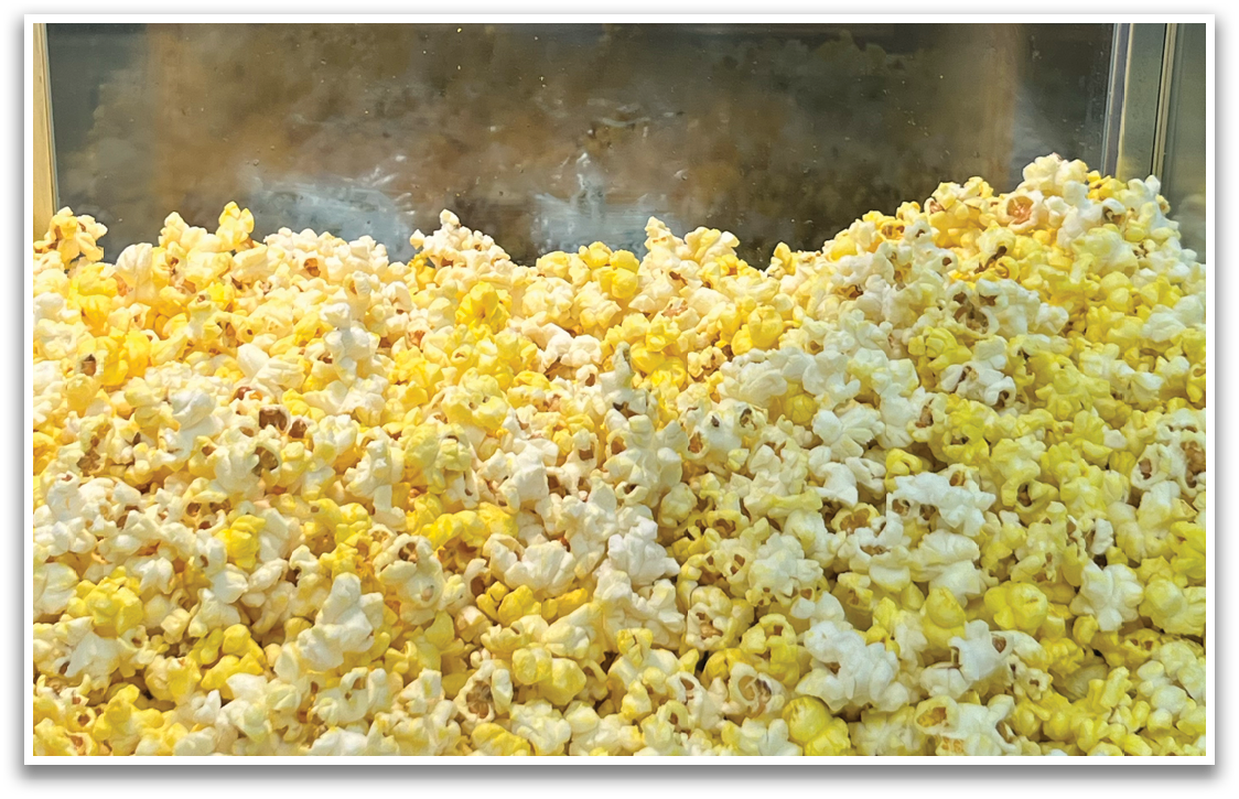 A machine is dispensing popcorn into a container. Contenido generado con IA