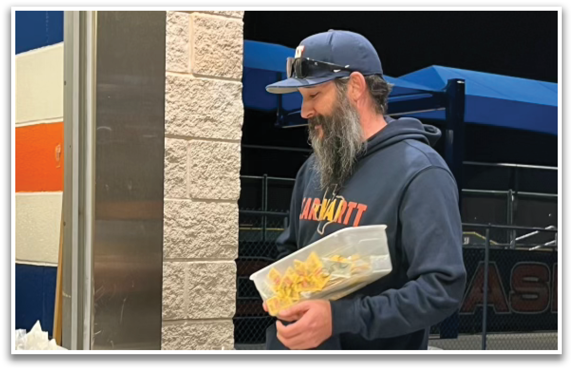 A man is holding a bag of food in front of a cash register. Contenido generado con IA