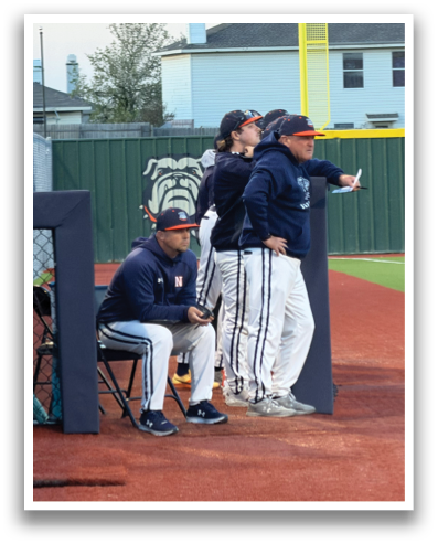 A group of men are standing on a baseball field, engaged in conversation. One man is holding a baseball bat, while another is holding a baseball glove. Contenido generado con IA