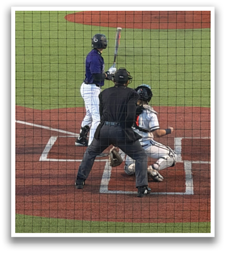 A baseball game is taking place on a field with a batter, catcher, and umpire. The batter is holding a baseball bat, ready to swing. Contenido generado con IA