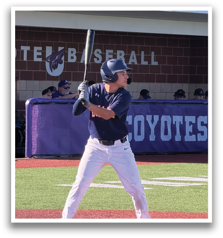 A baseball player is at bat, holding a bat and preparing to swing. The player is wearing a baseball glove. There are several other people in the background, some of whom are standing and others are sitting. Contenido generado con IA