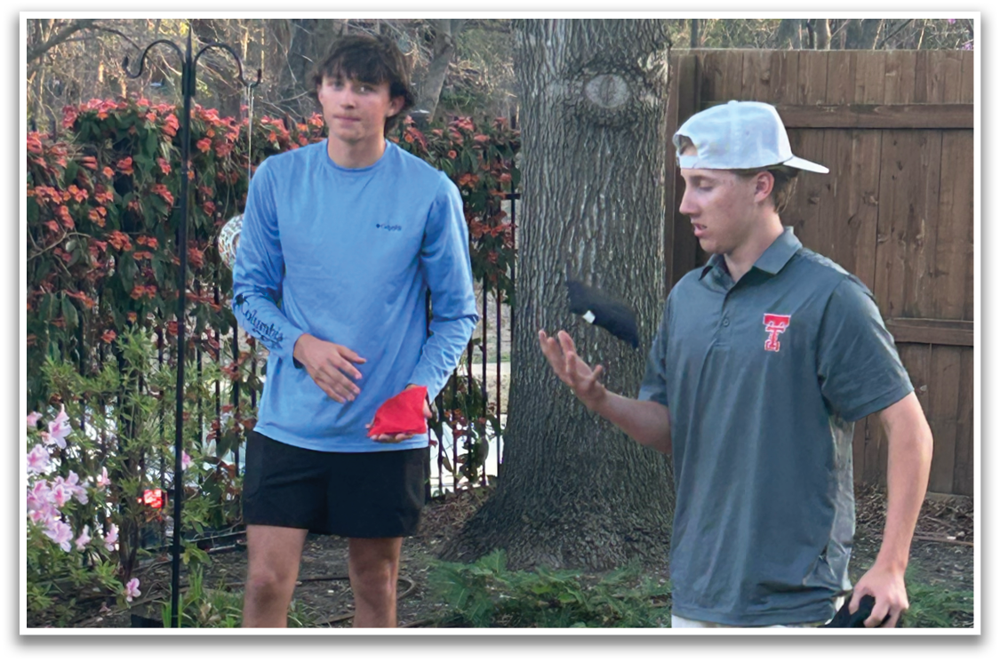 Two men are standing in a yard, playing with a frisbee. One man is wearing a blue shirt and the other is wearing a gray shirt. They are both holding frisbees in their hands. Contenido generado con IA