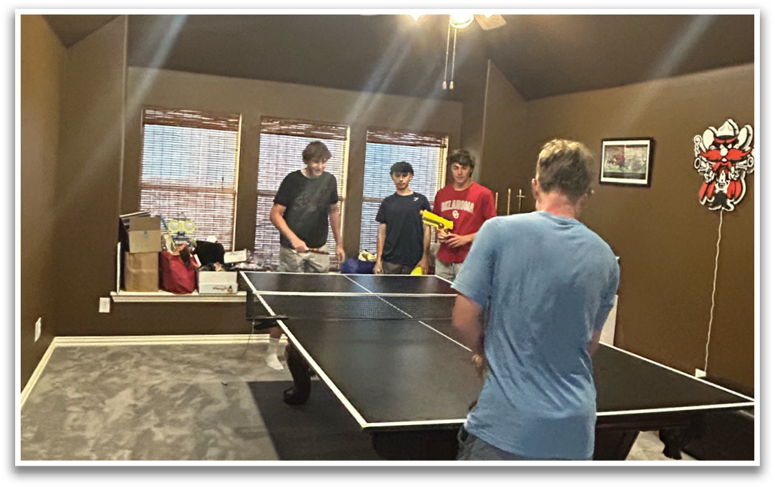A group of people are playing a game of ping pong in a room. Contenido generado con IA