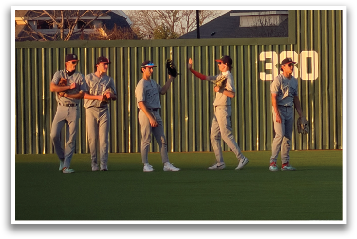 Four baseball players standing on a field, two of them wearing baseball gloves. Contenido generado con IA