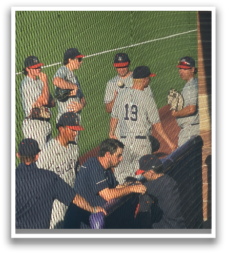Baseball players wearing grey uniforms are sitting on the grass. Contenido generado con IA