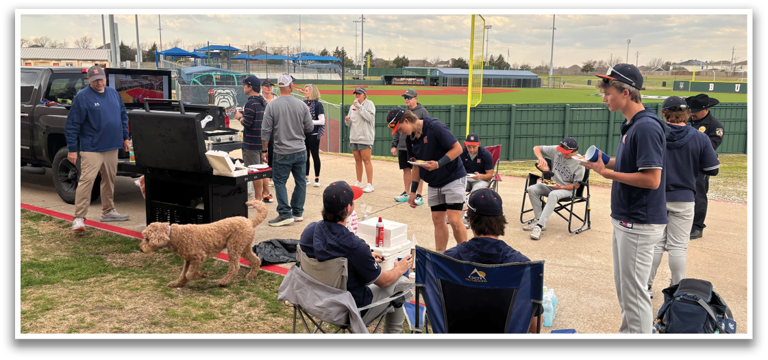 A group of people are gathered around a grill, eating and socializing. There are several chairs and a dog nearby. Contenido generado con IA