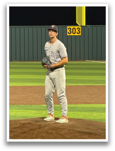 A baseball player is standing on the pitcher's mound, wearing a grey uniform and a cap. Contenido generado con IA
