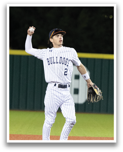 A baseball player in a white uniform stands on the field, holding a baseball glove. Contenido generado con IA