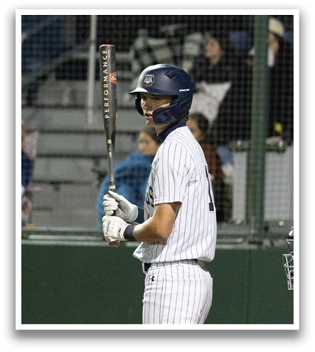 A baseball player stands at home plate, holding a bat and waiting for the pitch. Contenido generado con IA