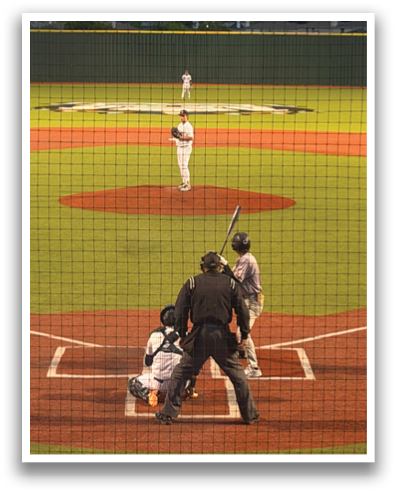 A baseball game is taking place with a batter, catcher, and umpire on the field. The batter is holding a baseball bat, ready to swing at the incoming pitch. Contenido generado con IA