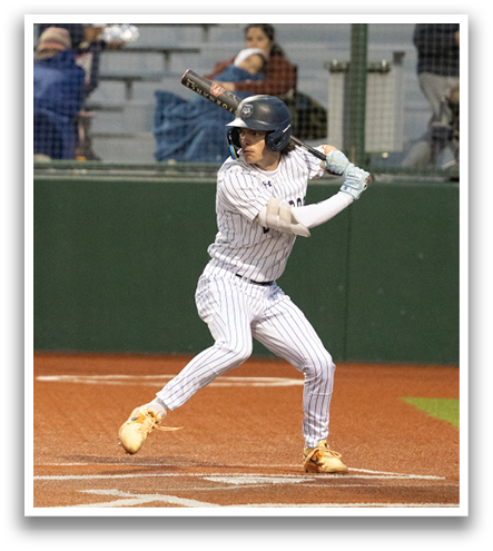 A baseball player in a grey uniform is swinging a bat on a field. Contenido generado con IA