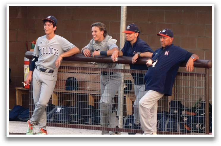 A group of men are standing around a fence, watching a baseball game. Contenido generado con IA