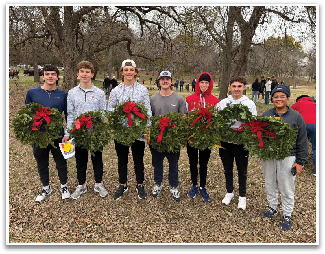 A group of young men pose with a large wreath. Contenido generado con IA