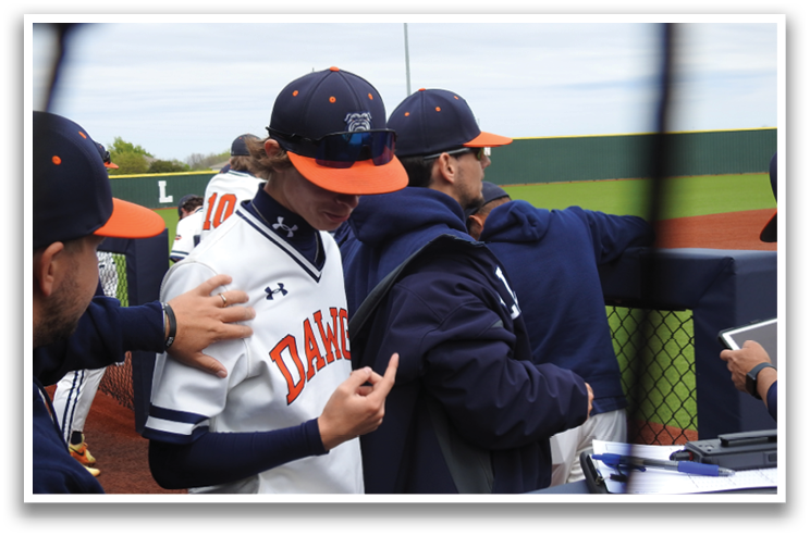 A group of baseball players huddle together, with one player pointing at another. Contenido generado con IA