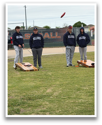 Four men are standing on a grassy field, playing a game of frisbee. One of the men is wearing a sweatshirt with the word “South" on it. Contenido generado con IA