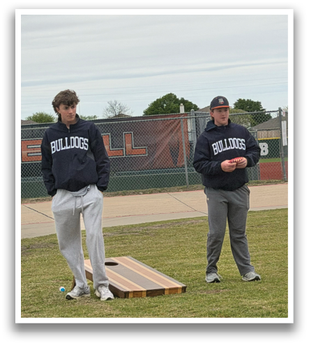 Two men are standing on a grassy field, playing a game of frisbee. One man is holding a frisbee in his hand, while the other is watching. Contenido generado con IA