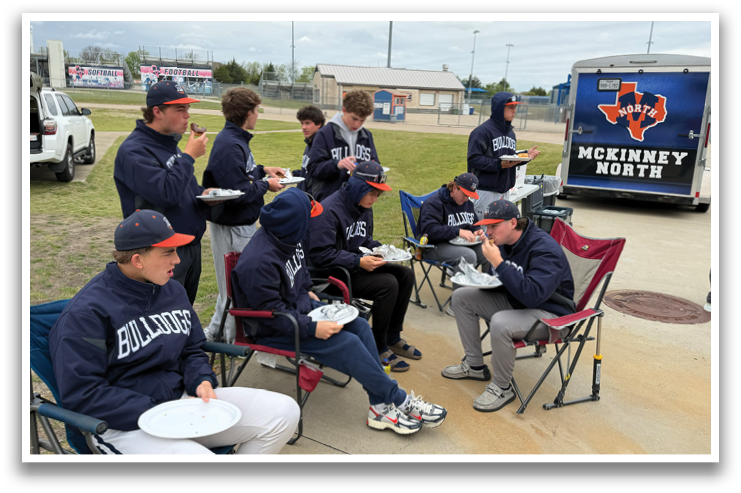 A group of people are sitting in chairs and eating pizza. They are wearing blue and orange shirts. Contenido generado con IA