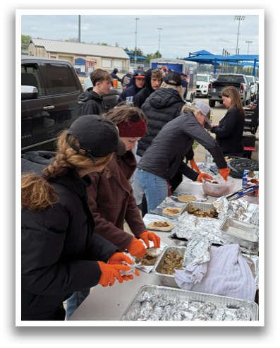 A group of people are standing around a table filled with food. Contenido generado con IA