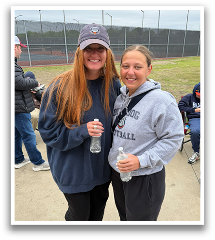 Two women standing next to each other, holding water bottles. Contenido generado con IA