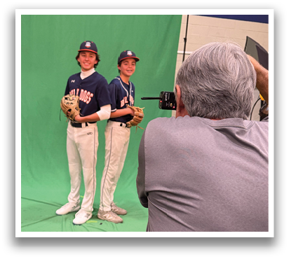 Two baseball players pose for a picture in front of a green backdrop. Contenido generado con IA