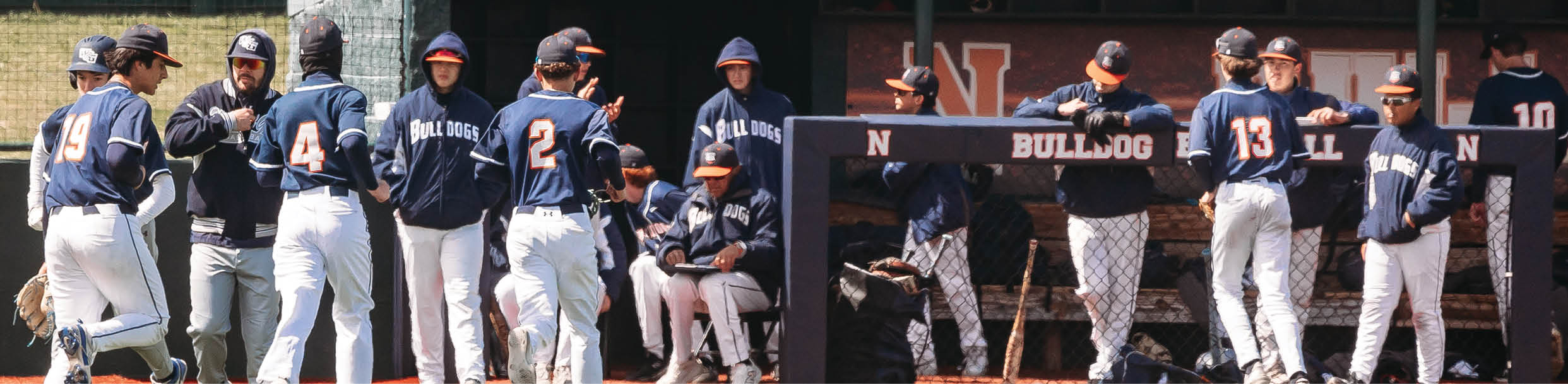 A group of baseball players are standing on the field, some of them wearing blue uniforms. Contenido generado con IA