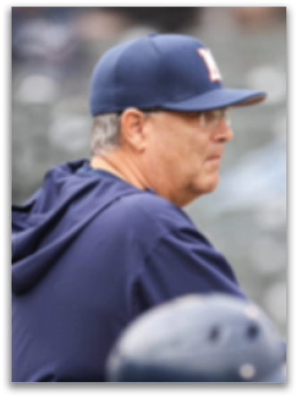 A baseball coach wearing a blue hat and jacket. Contenido generado con IA
