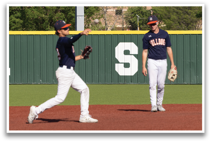 Two baseball players on a field, one is running towards the base while the other is standing. Contenido generado con IA
