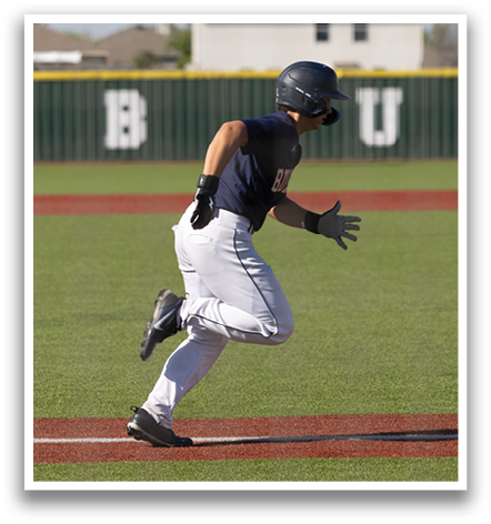A baseball player is running on the field, wearing a blue shirt and white pants. Contenido generado con IA