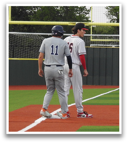 Two baseball players are standing on the field, one wearing a blue shirt and the other wearing a red shirt. They are talking to each other. Contenido generado con IA