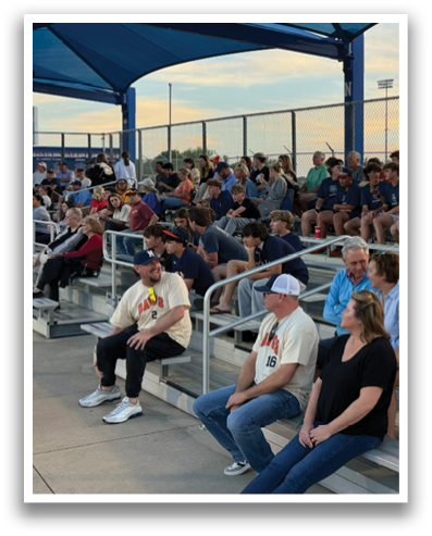A group of people are sitting on a bench at a baseball game. Contenido generado con IA