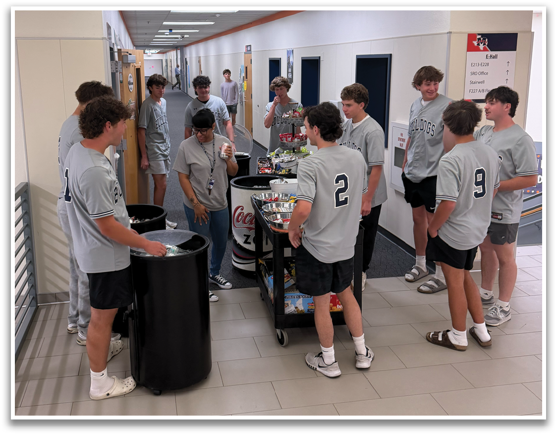 A group of people are standing in a hallway, wearing grey shirts. They are gathered around a luggage cart, which is filled with suitcases. Contenido generado con IA