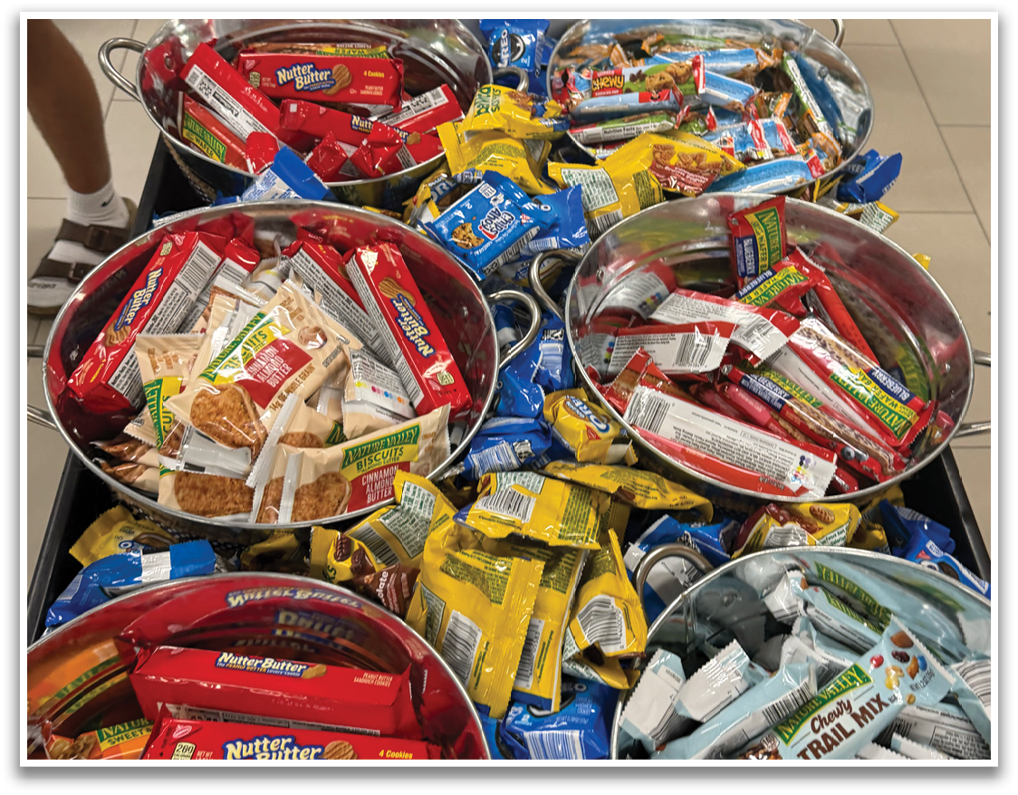 A large metal bowl filled with various snacks is placed on a table. Contenido generado con IA