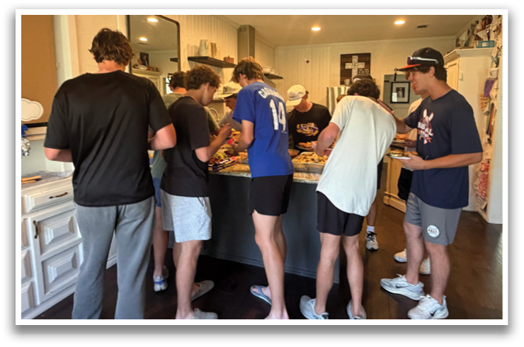 A group of people are gathered in a kitchen, preparing food and enjoying each other's company. Contenido generado con IA
