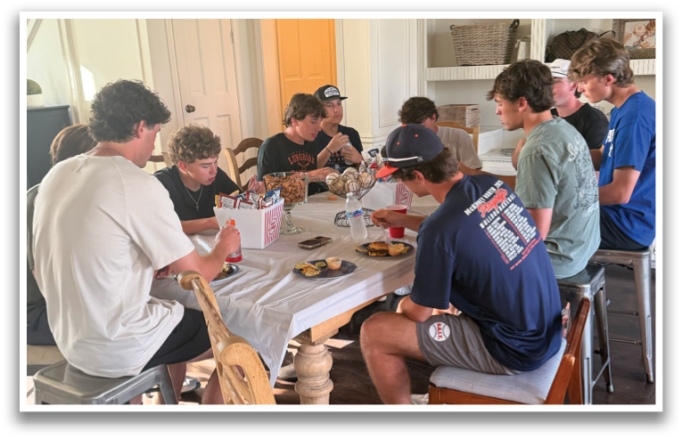 A group of people are sitting around a table, eating and drinking. Contenido generado con IA