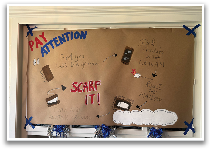 A sign on a wall that says “Pay Attention" and has a picture of a cell phone and a chocolate bar. Contenido generado con IA