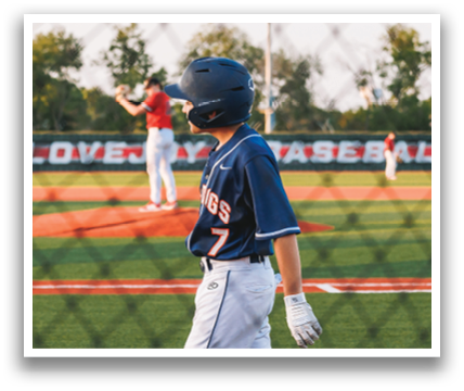A young boy wearing a baseball uniform is walking across a field. Contenido generado con IA