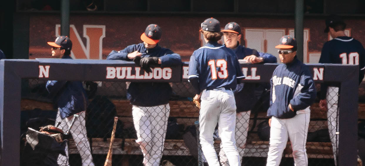 A group of baseball players are standing on the field, some of them wearing blue uniforms. Contenido generado con IA