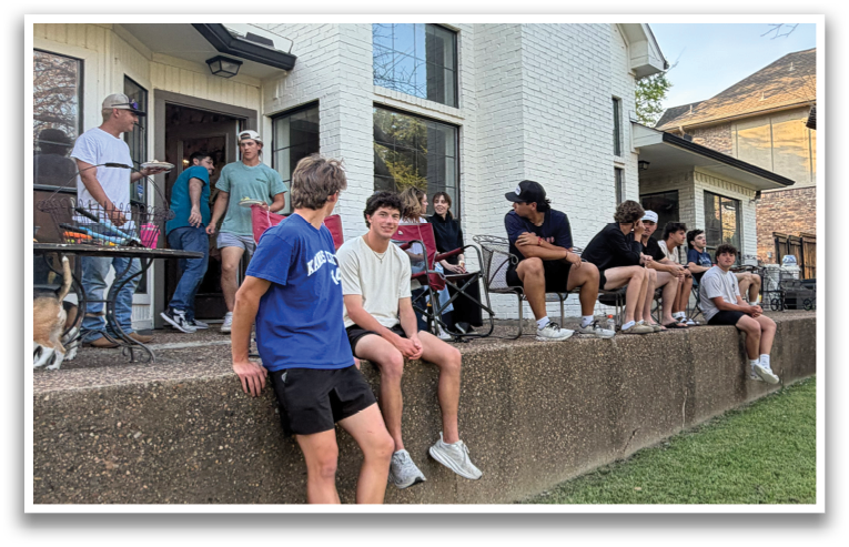 A group of people are sitting on a concrete wall outside a house. Contenido generado con IA