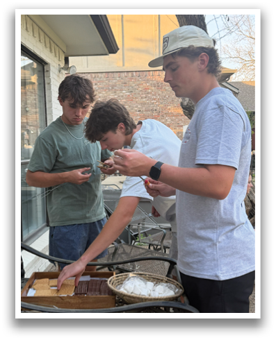 Three men are standing around a table, looking at their cell phones. Contenido generado con IA