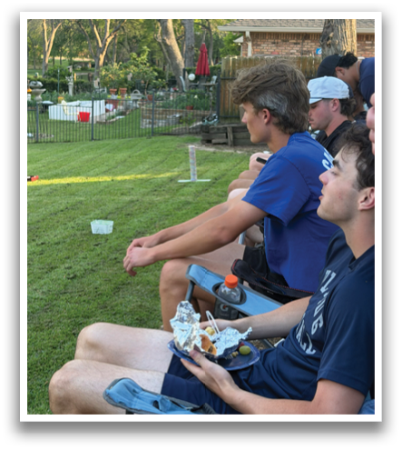 Three men are sitting on a bench, eating and drinking. One of them is holding a bottle. They are in a park setting. Contenido generado con IA