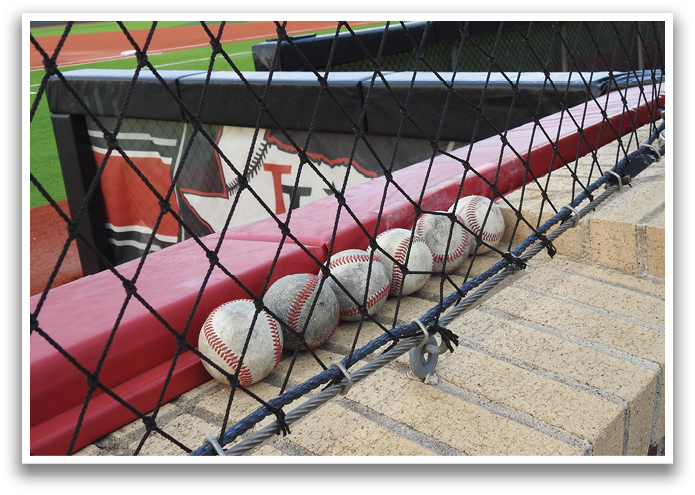 A baseball field with a fence and a bench. Contenido generado con IA