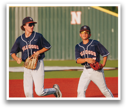 Three baseball players wearing blue jerseys and white pants are standing on a field. They are holding baseball gloves and are ready to play. Contenido generado con IA