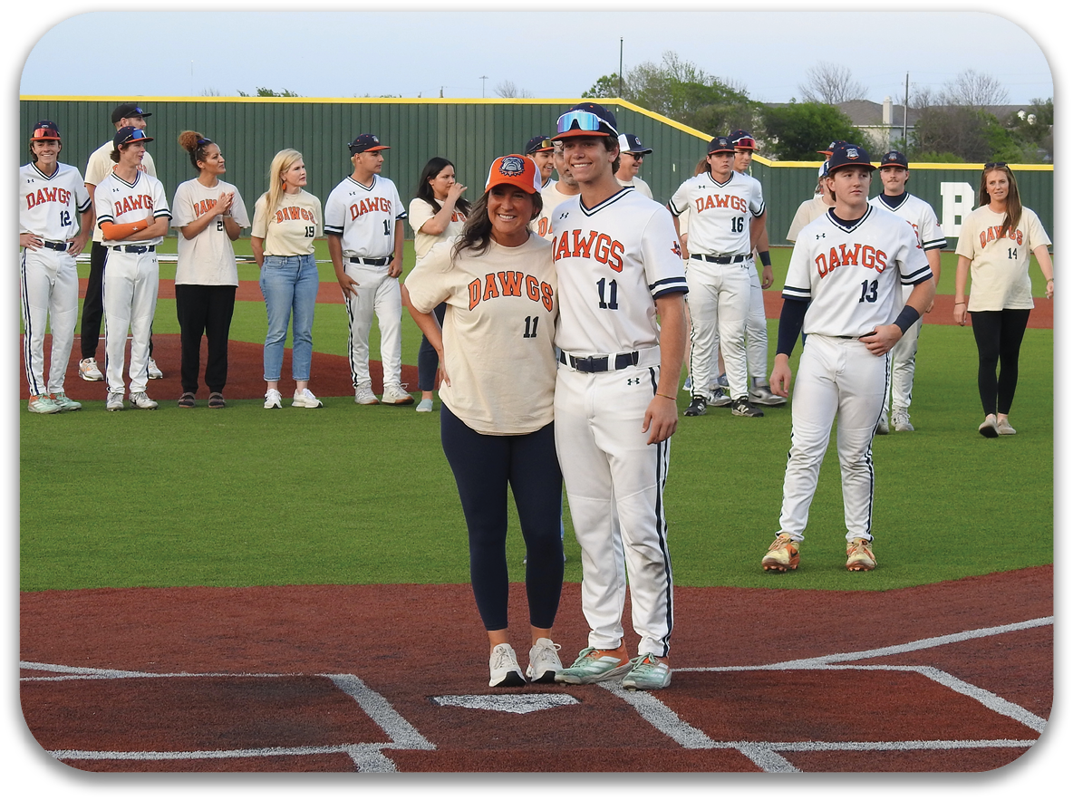 A man and woman stand on a baseball field, posing for a photo. They are surrounded by other people, some of whom are wearing baseball uniforms. The man is wearing a baseball glove. Contenido generado con IA