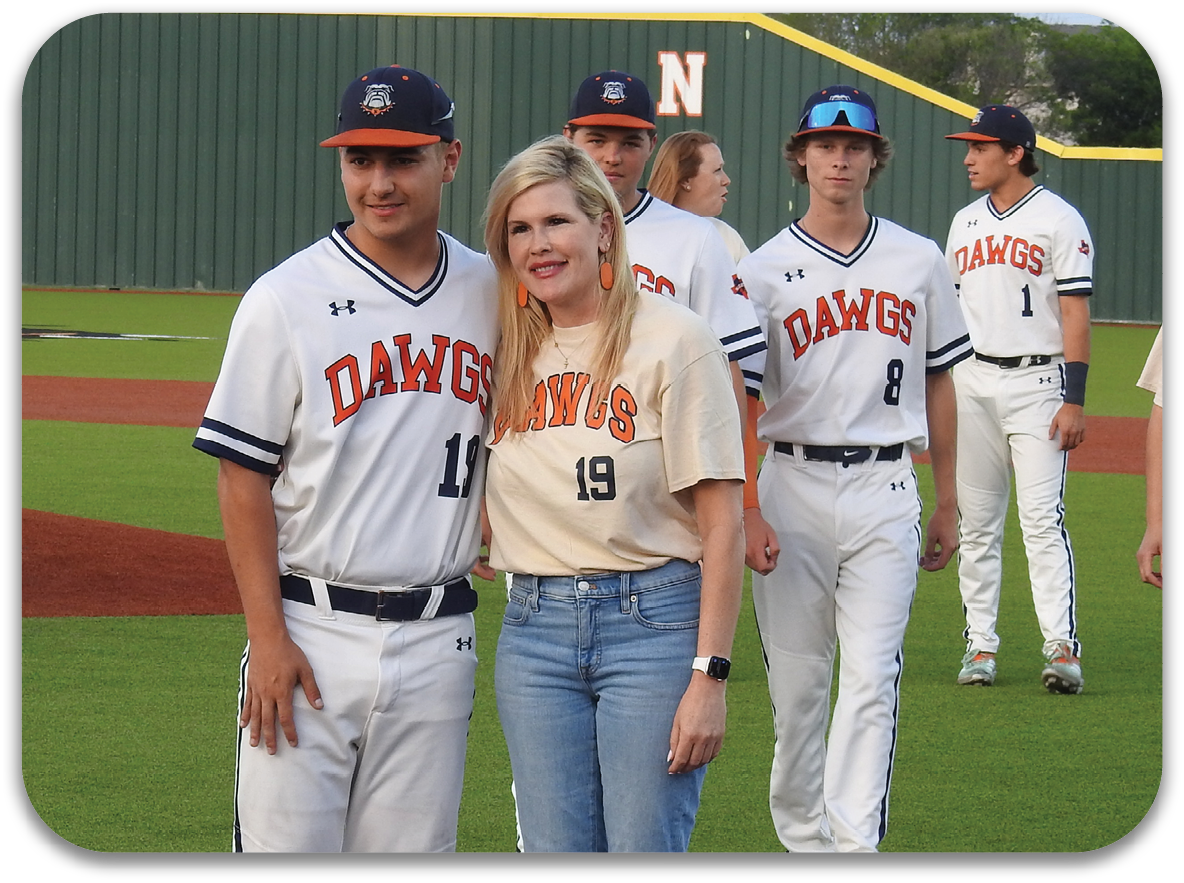 A man and woman stand on a baseball field, posing for a picture. The woman is wearing a yellow shirt. Contenido generado con IA