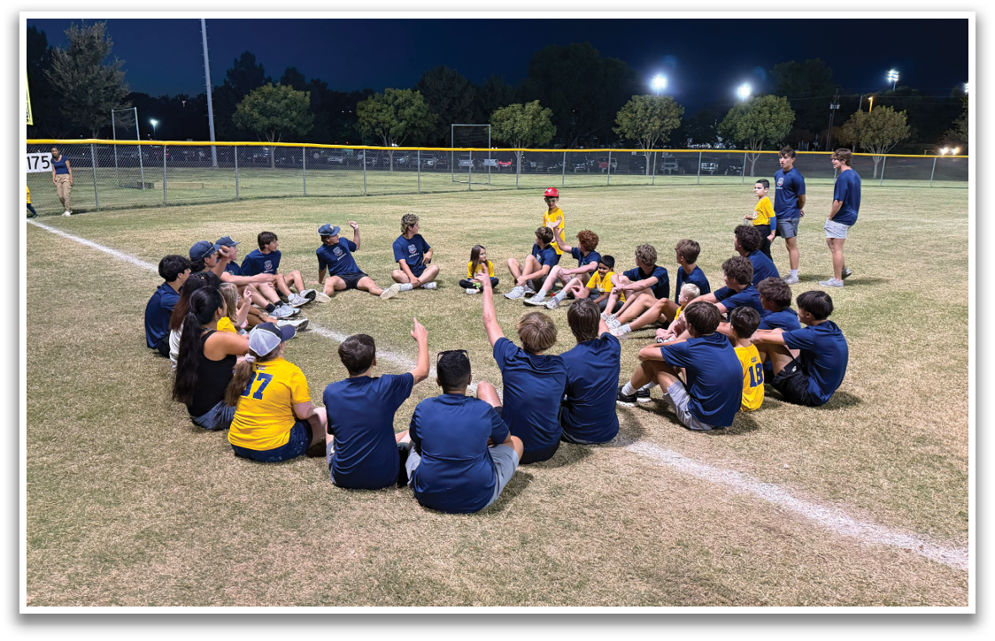 A group of young people are sitting on the grass in a circle, engaged in a conversation. Contenido generado con IA