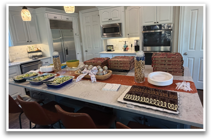 A kitchen counter with a cake and plates of food. Contenido generado con IA