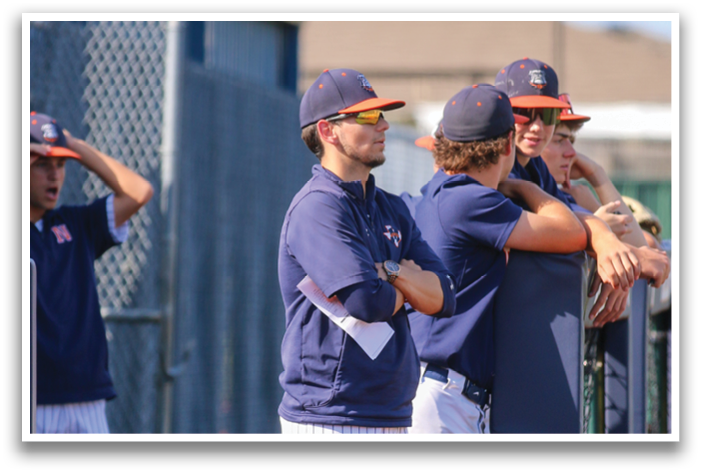 Baseball players in blue and orange uniforms are standing on a field. Contenido generado con IA