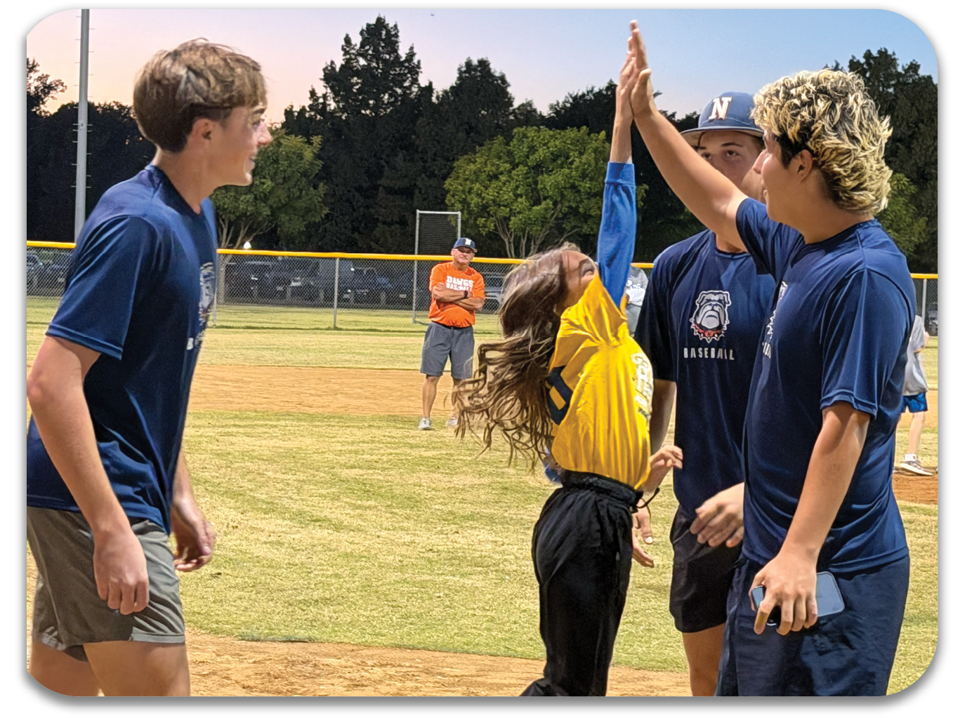 A young girl is lifted by two boys on a baseball field. Contenido generado con IA
