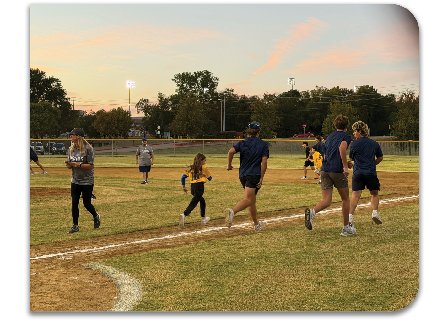 A group of people, including children, are playing baseball on a field. Contenido generado con IA